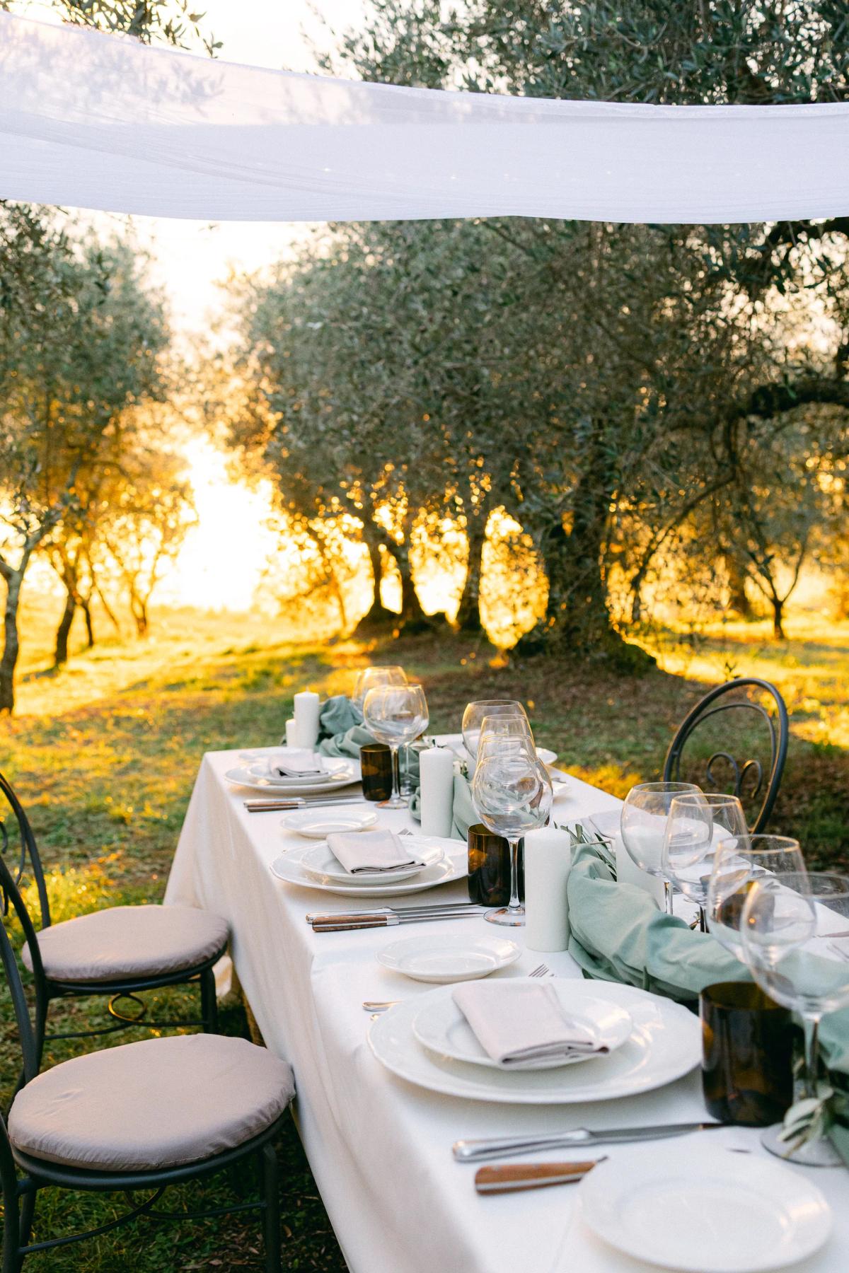 Wedding reception table illuminated by candles at dusk, lit by by Albine