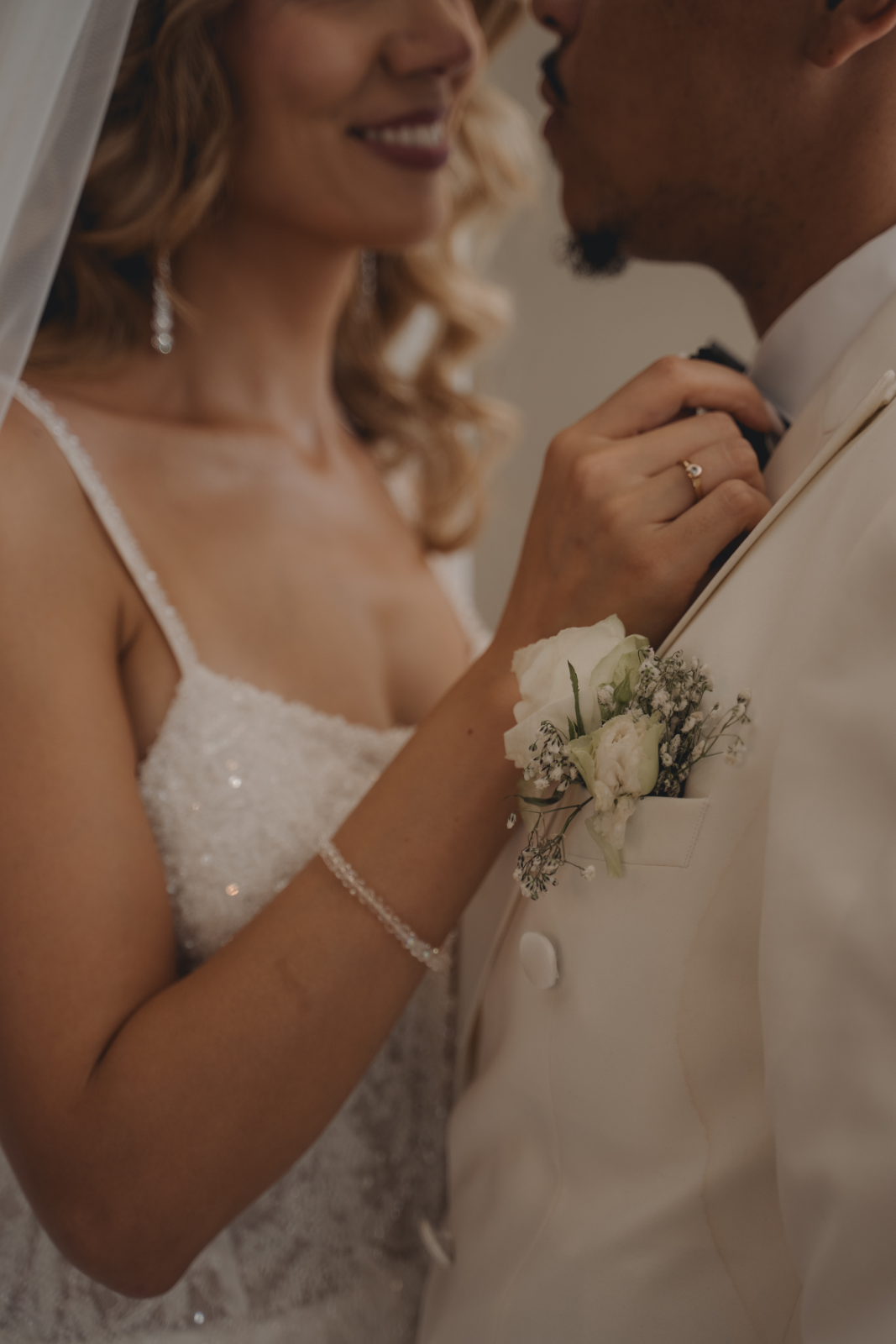 Close-up of a bride and groom embracing in natural light, by Fati Photographie
